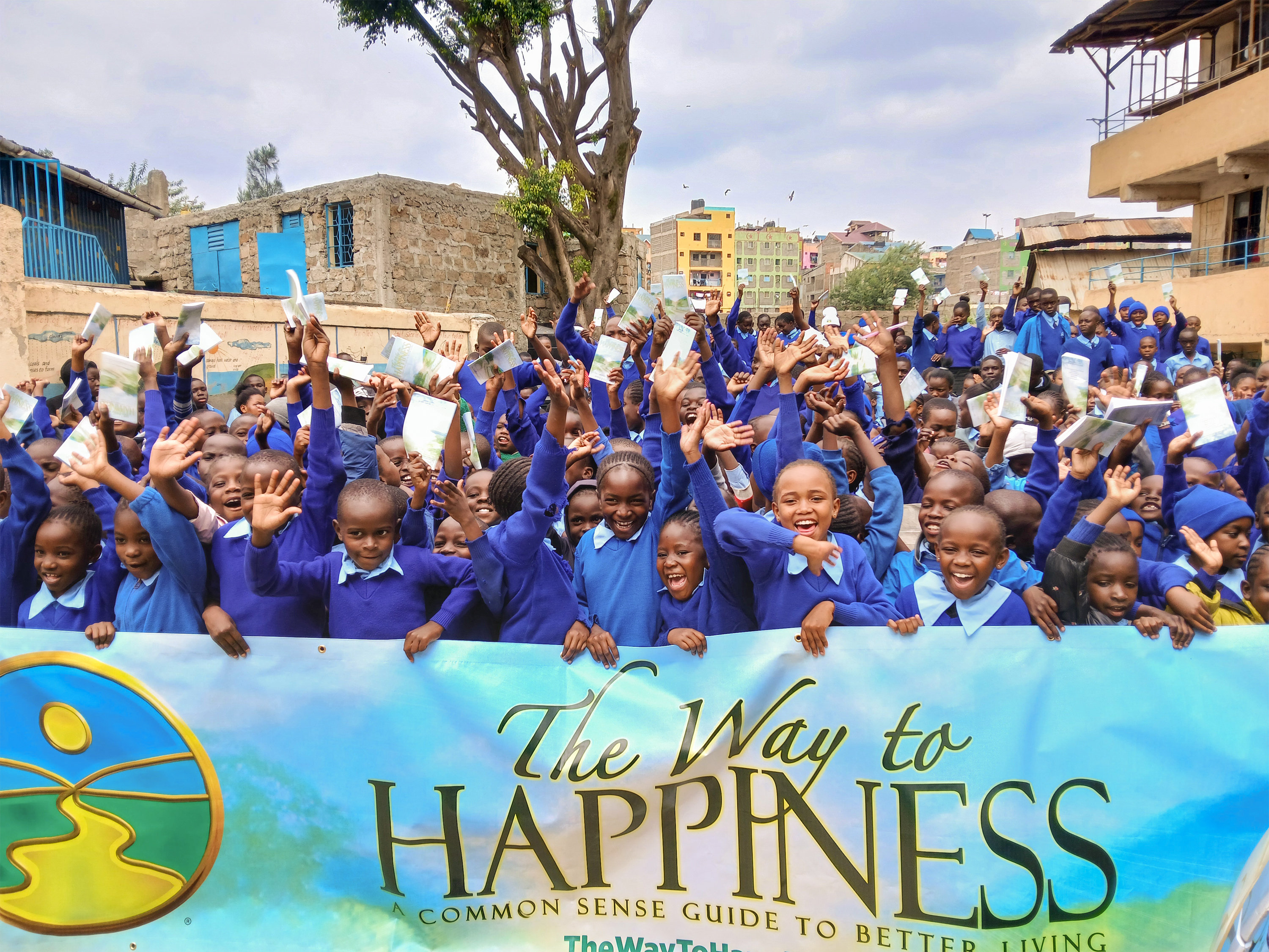 Students in Kenya holding The Way to Happiness banner